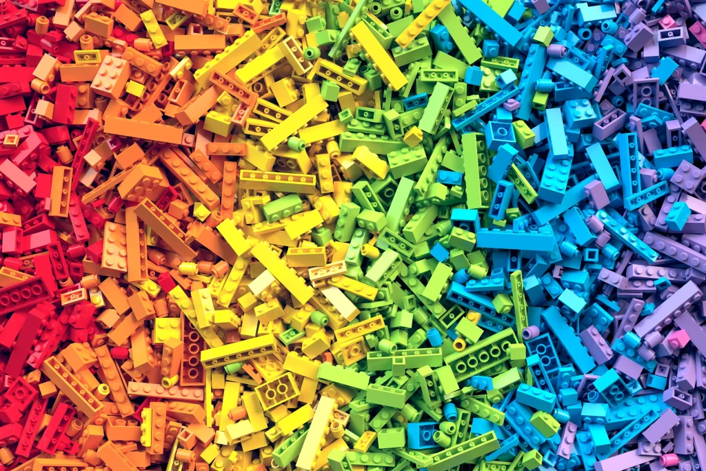 Colorful pile of LEGO bricks in a rainbow gradient, illustrating the LEGO turnaround strategy from chaos to alignment.